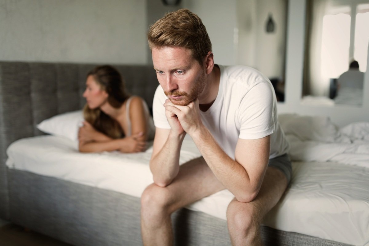 Two people looking stressed and disconnected because sex feels pressured.